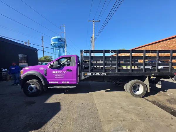 Vehicle lettering on a purple stake-body work truck by Marv'les Signs