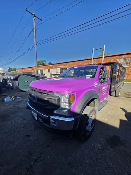 Vehicle lettering on a purple stake-body work truck by Marv'les Signs